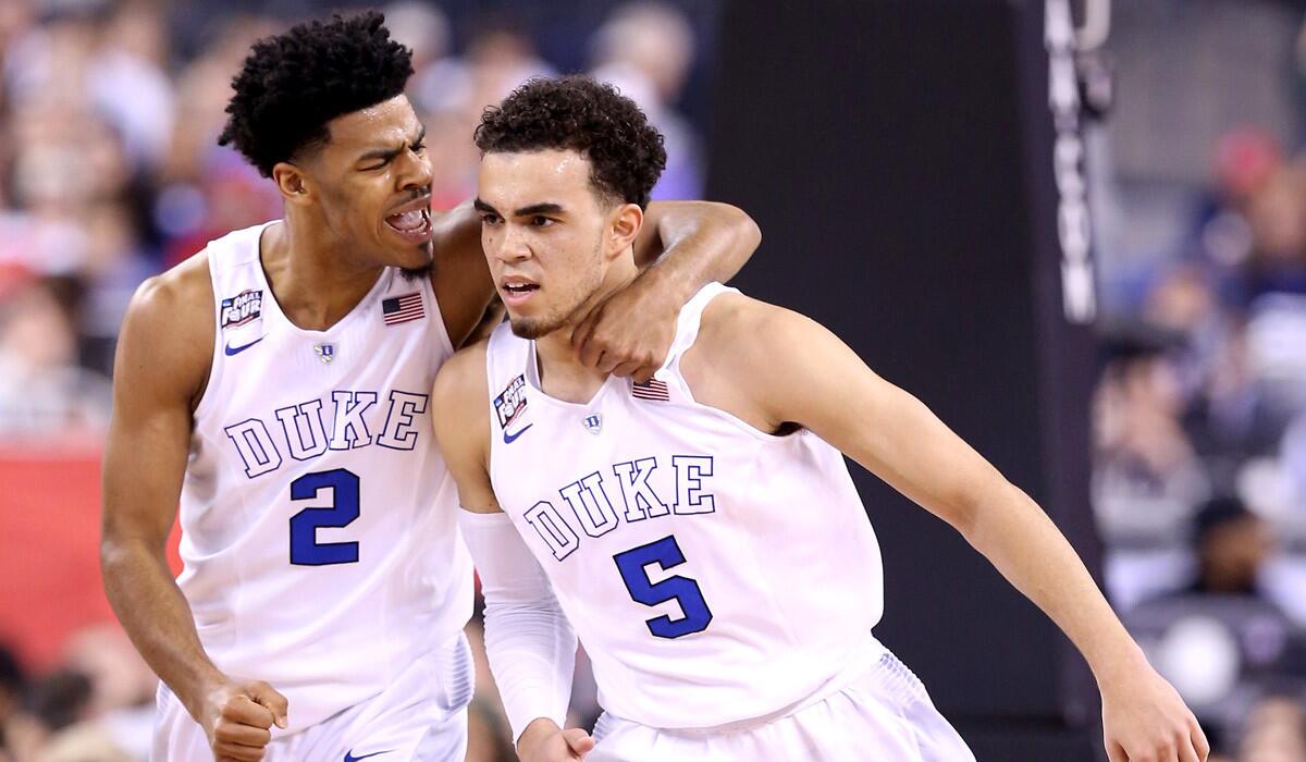 Duke's Quinn Cook, left, and Tyus Jones celebrate after a play in the first half of their Final Four matchup against Michigan State this year.