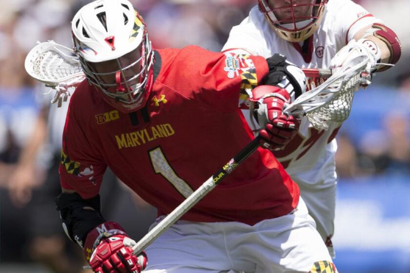 Matt Rambo of the Maryland Terrapins is guarded by Garret Holst of the Denver Pioneers during a game on May 25.