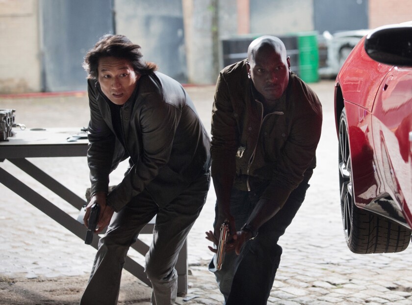 (L to R) Han (SUNG KANG) and Roman (TYRESE GIBSON) lock and load in "Fast & Furious 6."
