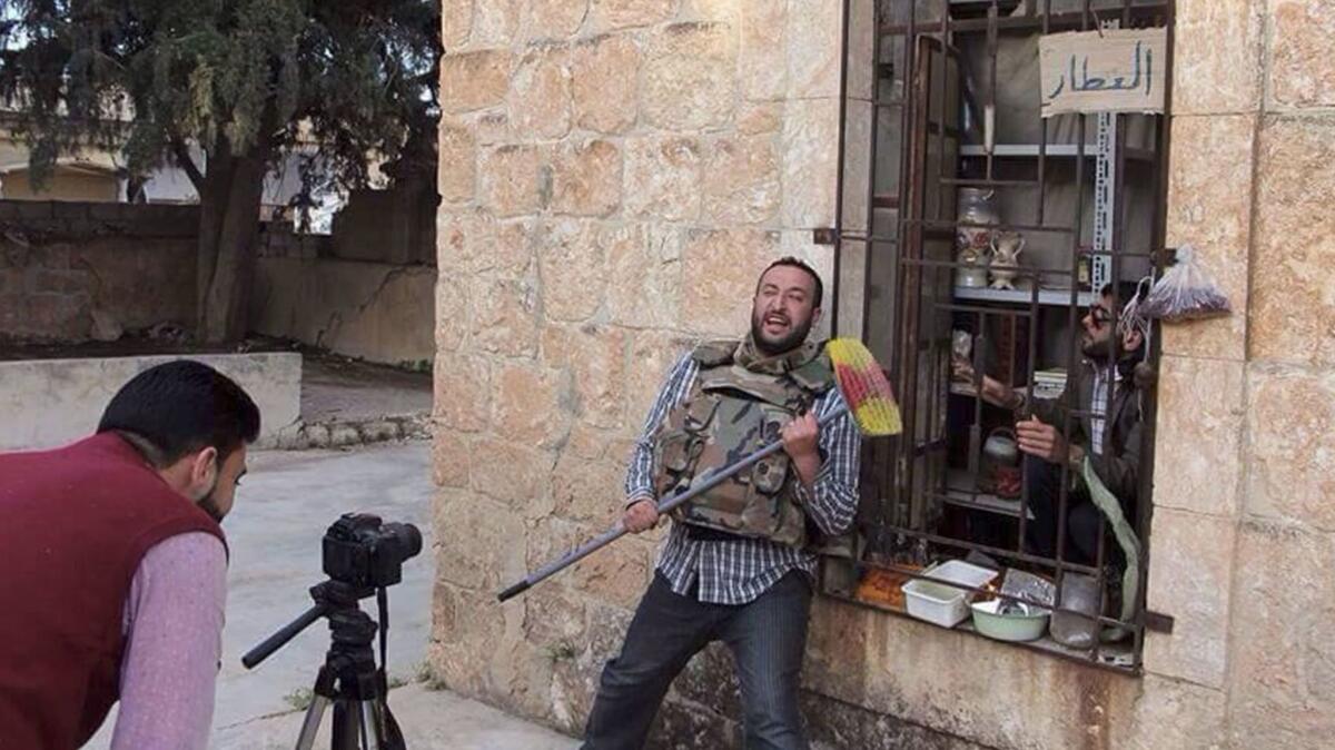 Ahmad Khatab, center, and Walid Abu Rashid, right, founders of the Syrian volunteer theater troupe Saraqeb Youth Group, perform in a sketch produced by the group, filmed in Saraqeb.