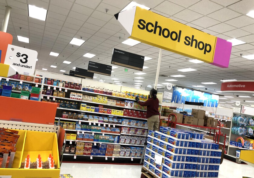 A worker stocks shelves of back-to-school supplies at a Target store.