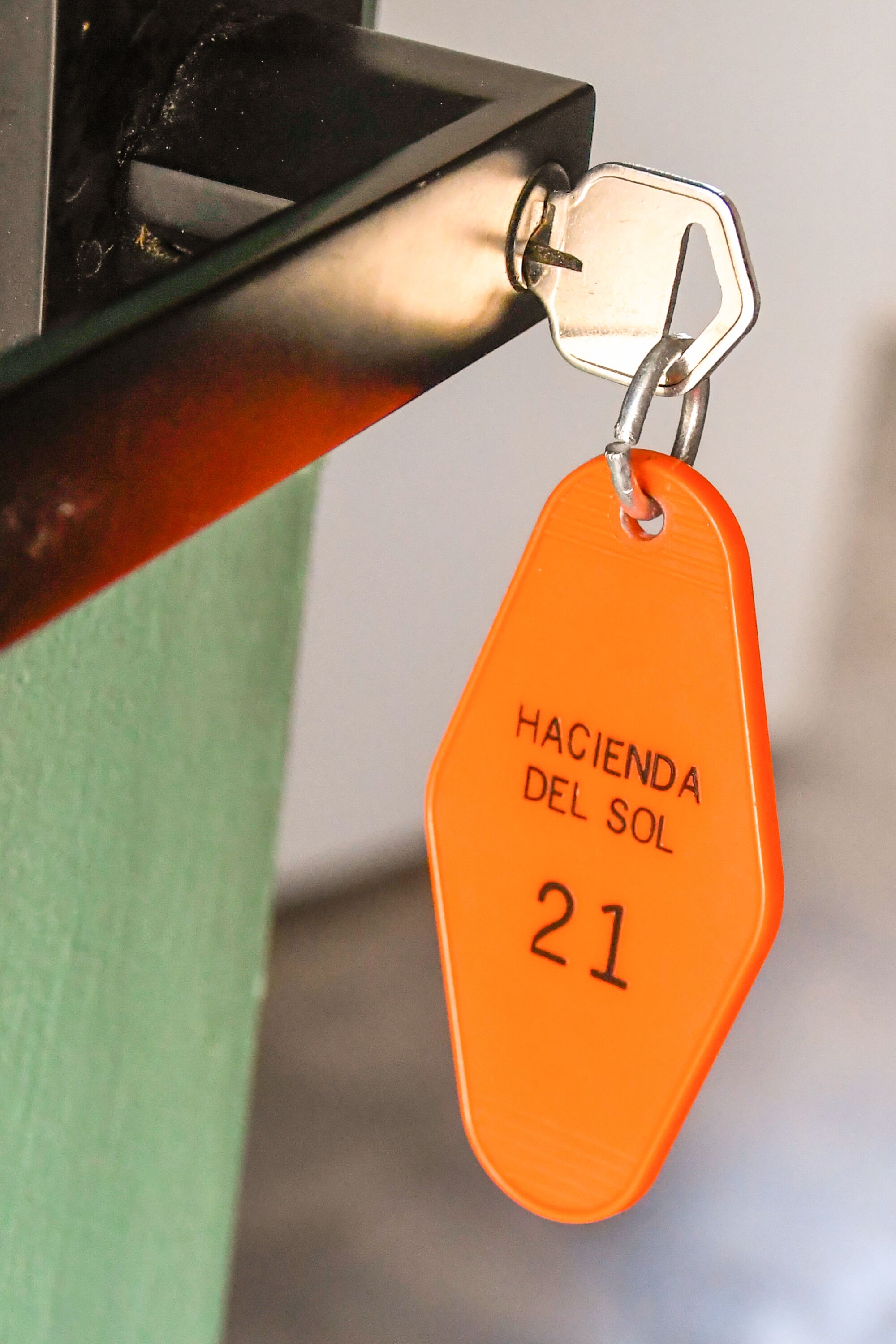 A orange tag on a key in a door handle reads "Hacienda del Sol 21"