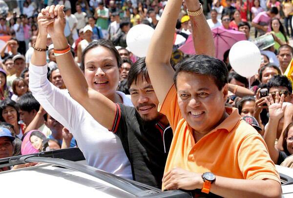 World champion boxer Manny Pacquiao campaigns for a seat in Congress between vice presidential candidate Loren Legarda (left) and presidential candidate Manny Villar (right) in the southern Philippine province of Sarangani. Pacquiao, considered the best pound-for-pound fighter in the world, faces a big challenge against a challenger from a wealthy family.