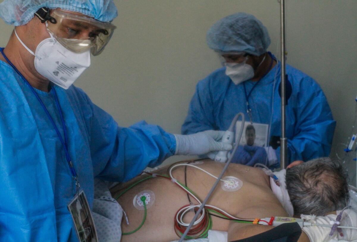 Los médicos Miguel Vázquez (i) y Damián Gutiérrez (d) revisan a un paciente con covid-19 para evaluar la condiciones de sus pulmones, en el Hospital Ángeles, en la ciudad de Tijuana, estado de Baja California (México).