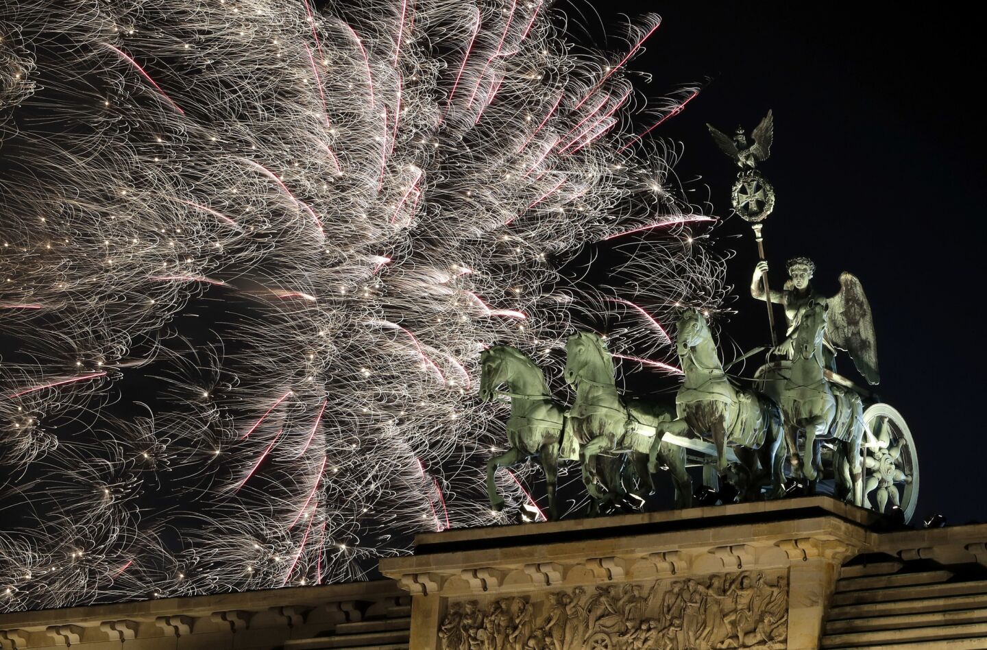 In Berlin, fireworks light up the Quadriga (a chariot and four horses) atop the Brandenburg Gate.