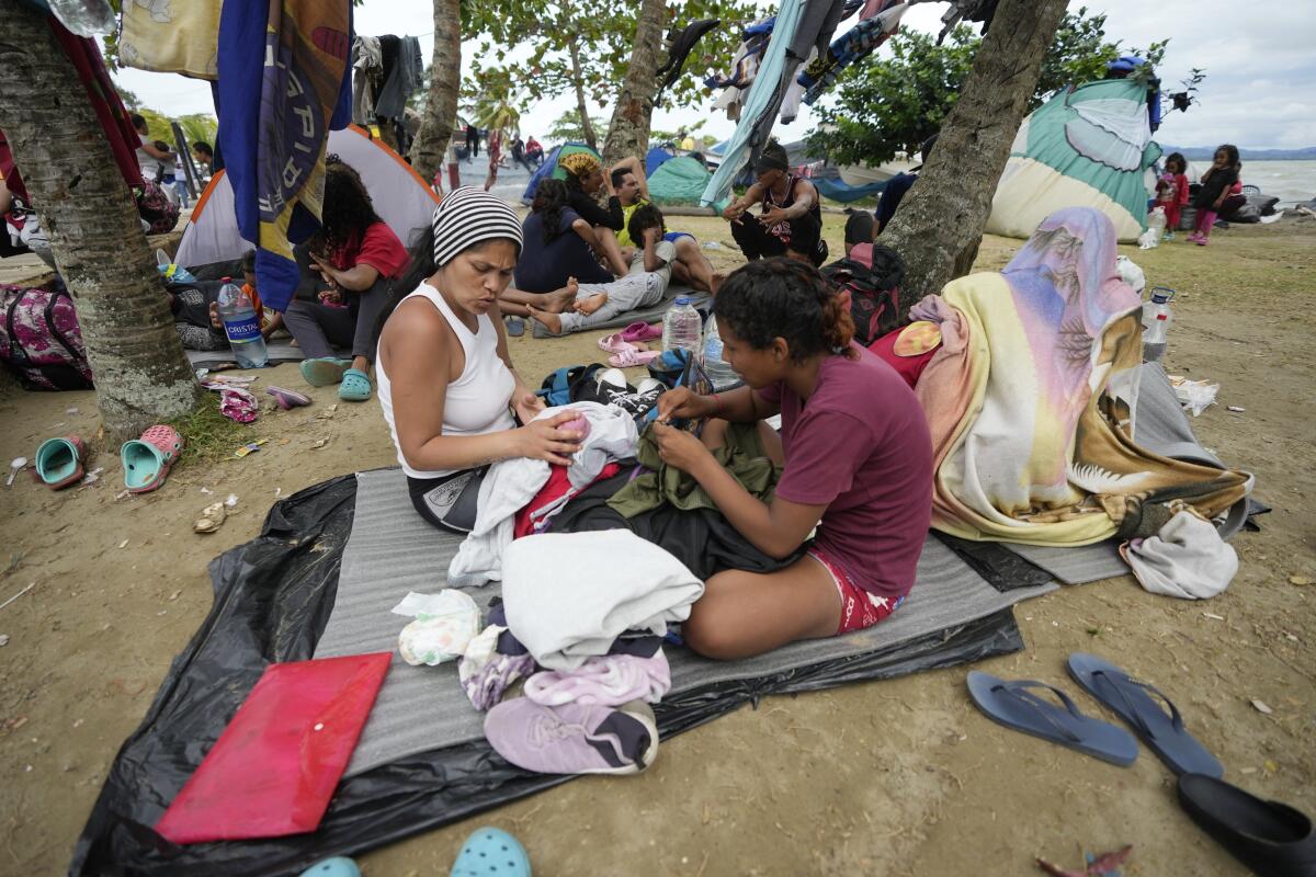 Migrantes venezolanos descansan en la playa mientras esperan un bote para dirigirse a Acandí