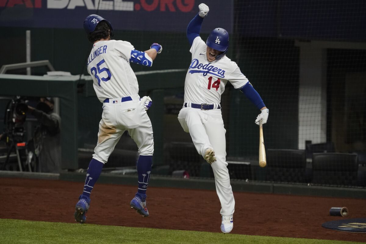 El jugador de los Dodgers de Los Ángeles Cody Bellinger celebra su jonrón con Kiké Hernández.