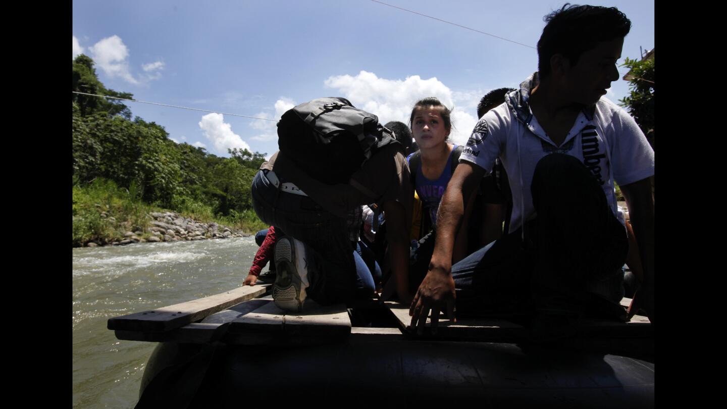 A girl, who refused to be identified, looks nervously from a raft crossing the Suchiate River near El Carmen, Guatemala, directly beneath the border crossing bridge that joins Mexico and Guatemala. She was beginning a trip to the United States.