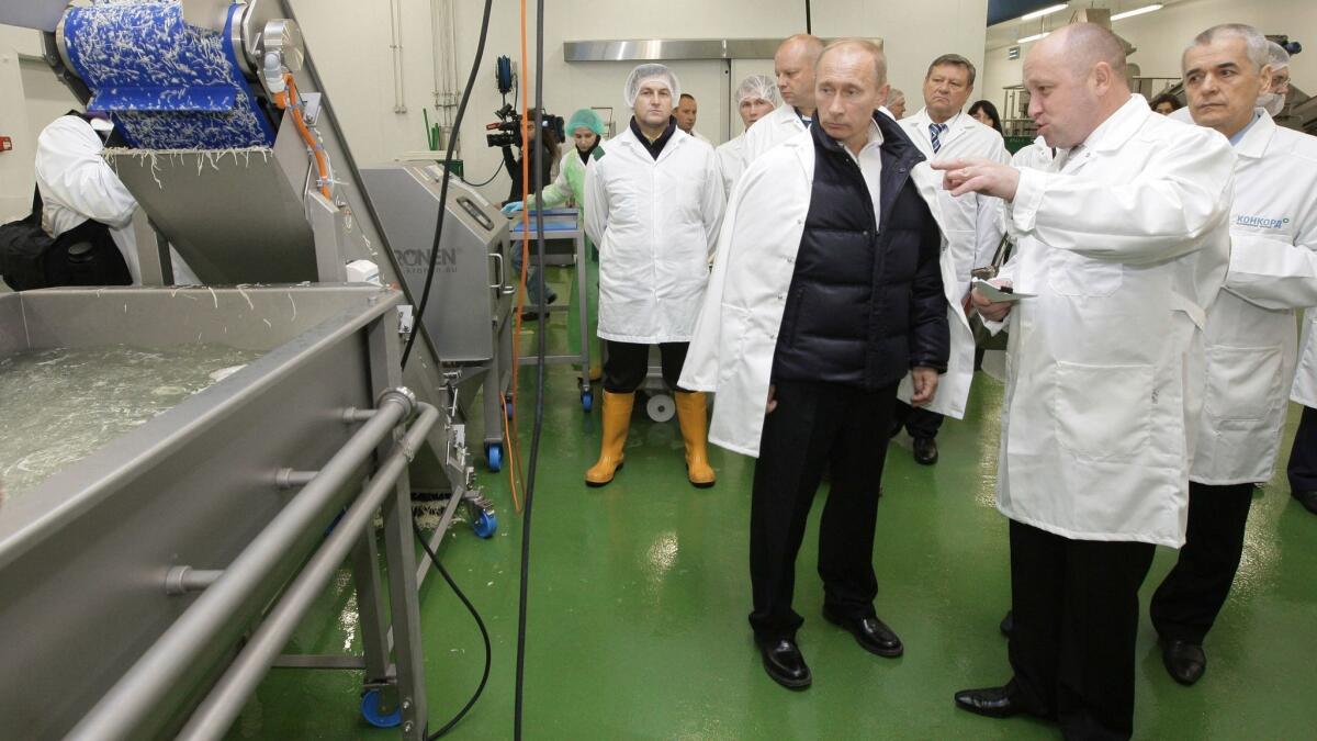 In this pool photo taken on Sept. 20, 2010, businessman Yevgeny Prigozhin, second from the right, shows Russian President Vladimir Putin, center, around his Concord Catering factory, which produces school lunches, outside St. Petersburg, Russia.