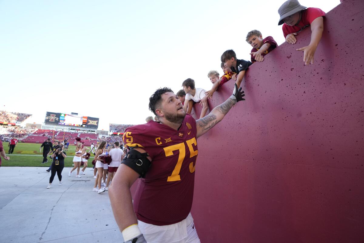 Iowa State offensive lineman Sean Foster (75) high-fives fans after the 16-10 win over Northern Iowa in an NCAA college football game, Saturday, Sept. 4, 2021, in Ames, Iowa. (AP Photo/Matthew Putney)