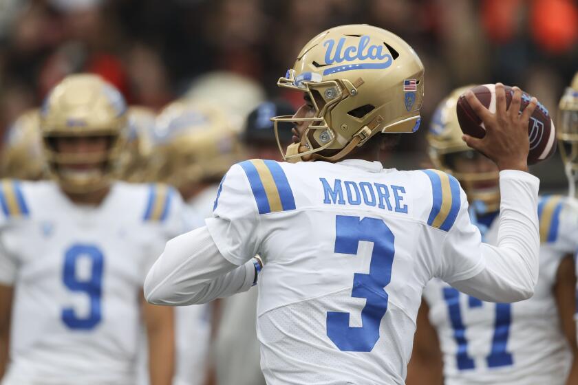 UCLA quarterback Dante Moore warms up before a game.