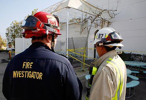 Orange County Fire Authority Battalion Chief Scott Brown, right, confers with an investigator looking into a deadly explosion at Solus Industrial Innovations in Rancho Santa Margarita that also left two people injured.