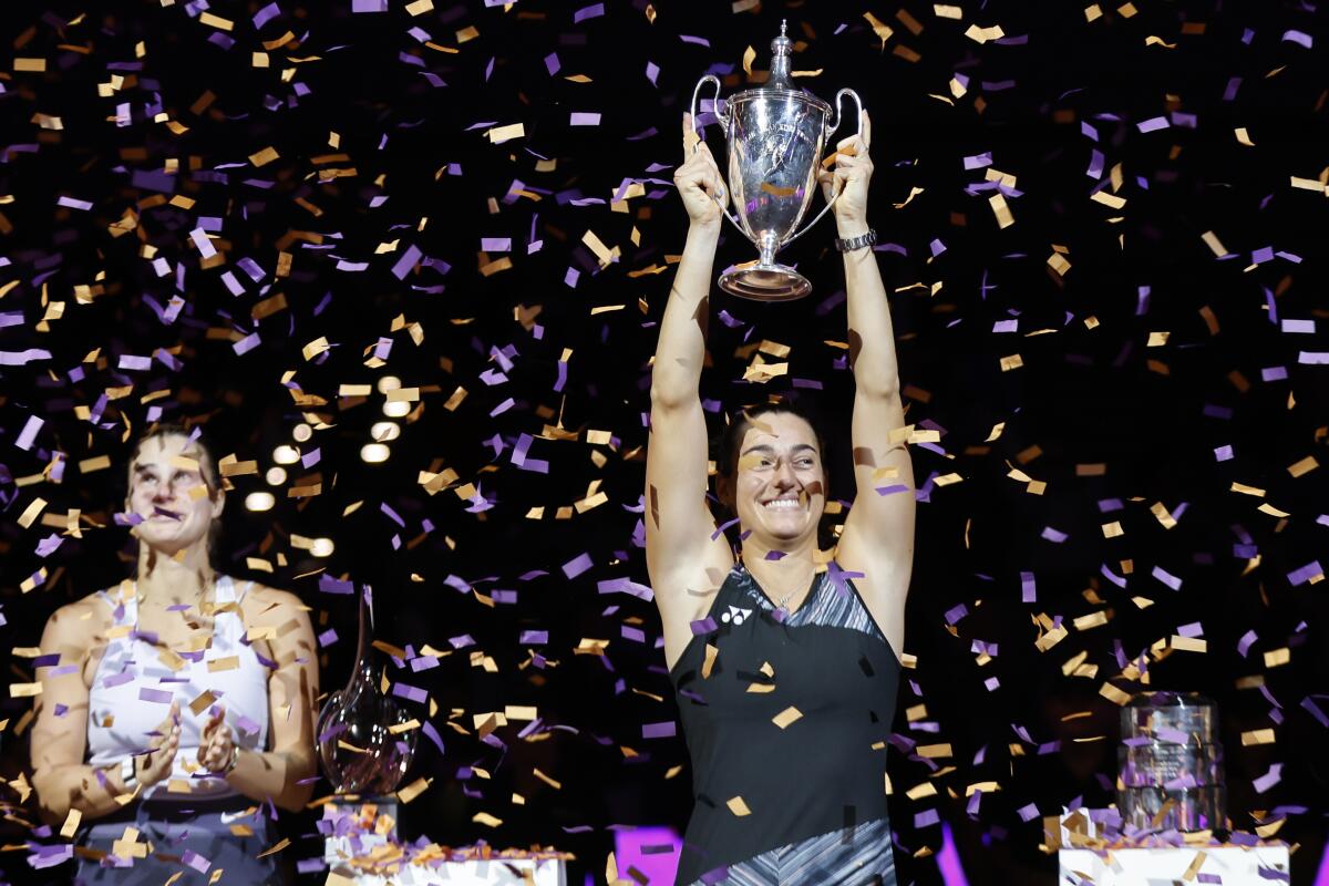 Caroline Garcia, right, of France, holds the trophy after defeating Aryna Sabalenka, left, of Belarus, in the singles final at the WTA Finals tennis tournament in Fort Worth, Texas, Monday, Nov. 7, 2022. (AP Photo/Ron Jenkins)