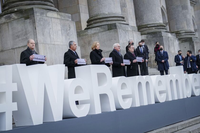 German Chancellor Olaf Scholz, Mickey Levy, Speaker of the Knesset, Bärbel Bas, President of the Bundestag, German President Frank-Walter Steinmeier and Bodo Ramelow, Prime Minister of Thuringia and President of the Bundesrat, from left, stand in front of the Reichstag building after the memorial hour for the "Day of Remembrance of the Victims of National Socialism" at the lettering "#weremember" (We remember) in Berlin, Germany, Thursday, Jan.27, 2022. (Kay Nietfeld/dpa via AP)