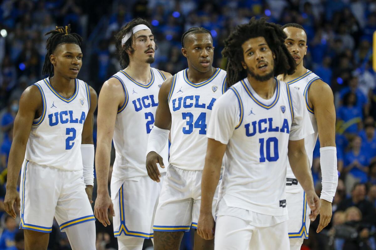 UCLA players Dylan Andrews, Jaime Jaquez Jr., David Singleton, Tyger Campbell and Amari Bailey stand on the court.