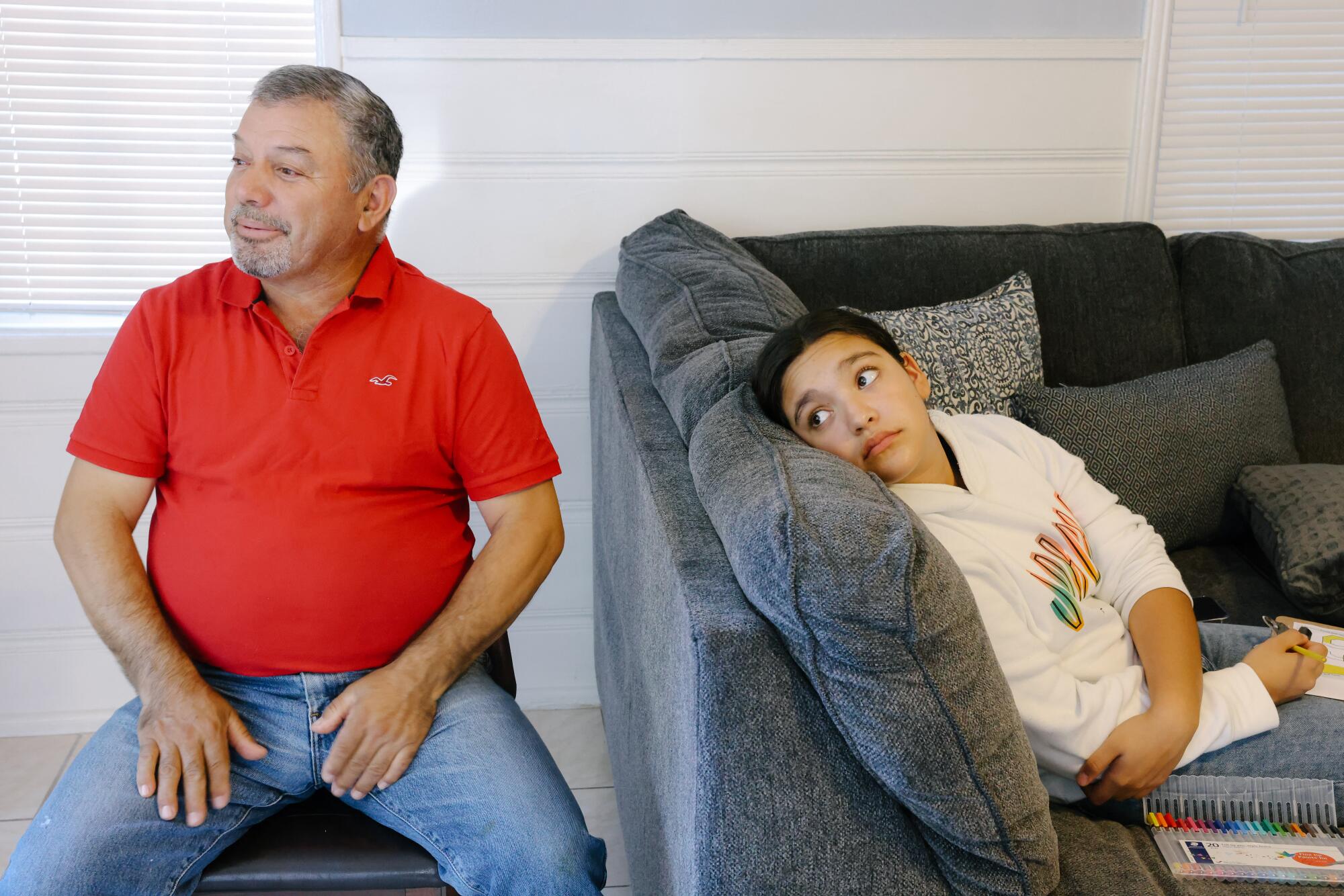  Joaquin Hurtado sits at home with his daughter.