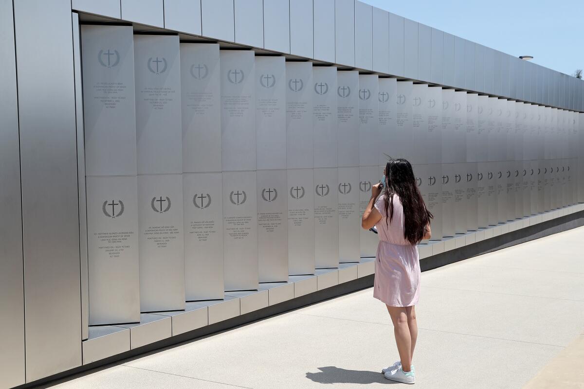 A reporter views the martyr wall at the new shrine at Christ Cathedral in Garden Grove.
