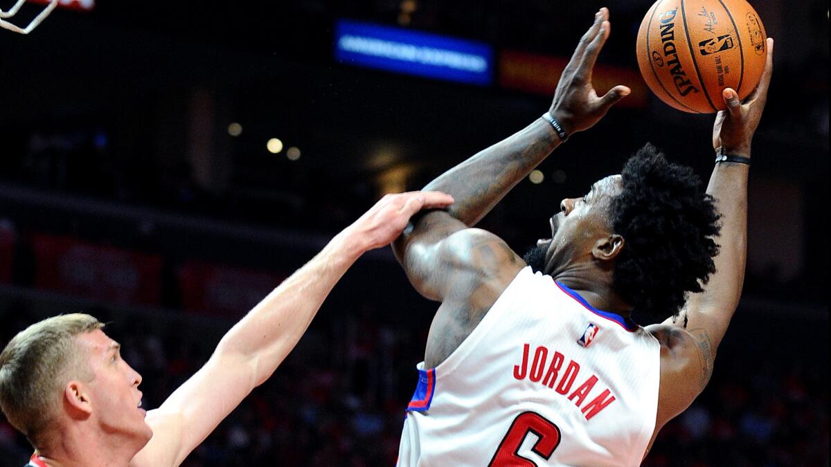 Clippers center DeAndre Jordan is fouled by Trail Blazers center Mason Plumlee while attempting a shot during Game 1 on Sunday.