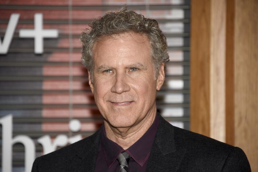Will Ferrell in a black suit posing at a red carpet event