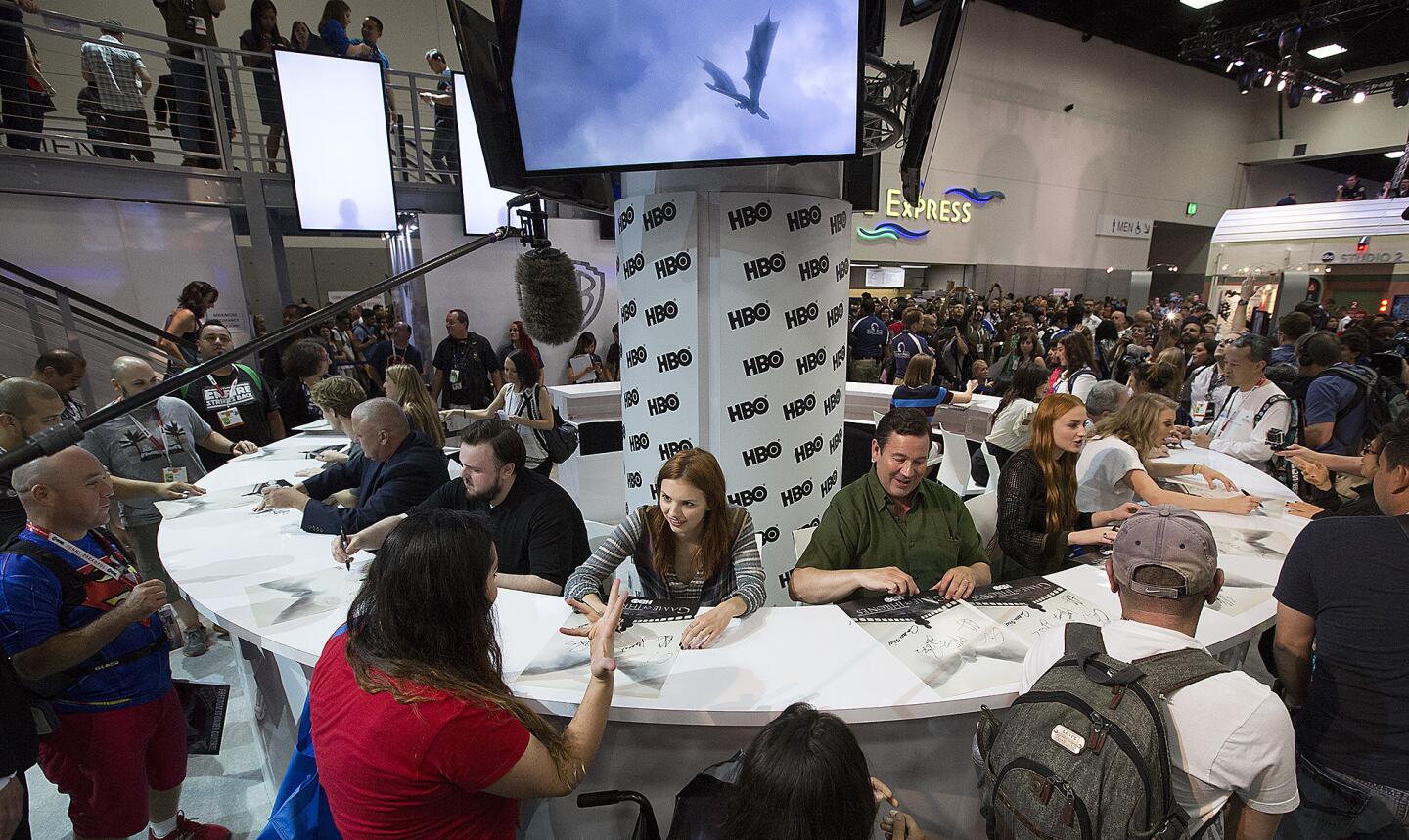 "Game of Thrones" cast members sign posters for fans at Comic-Con.