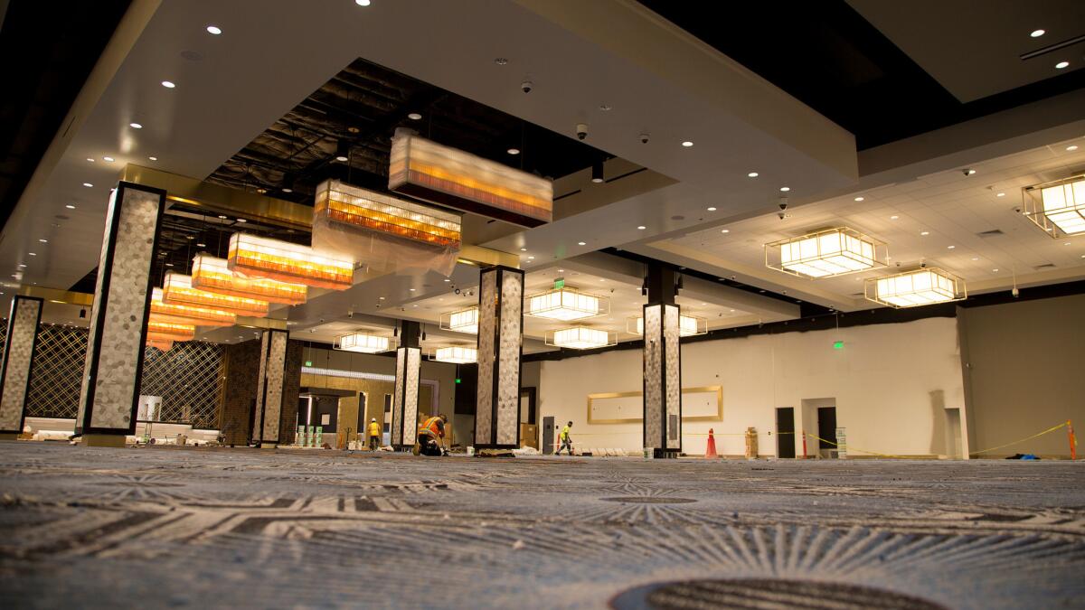 Construction workers finish gluing carpet this week in the main casino room of the revamped Hollywood Park Casino off of West Century Boulevard in Inglewood.