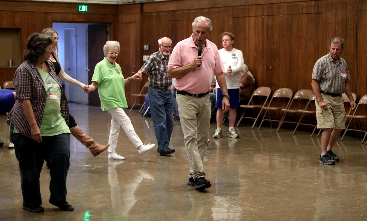 Dance instructor and square-dance caller Dale Hopper leads dancers during a class held in the recreation hall at the Magnolia Park Methodist Church in Burbank on Tuesday.