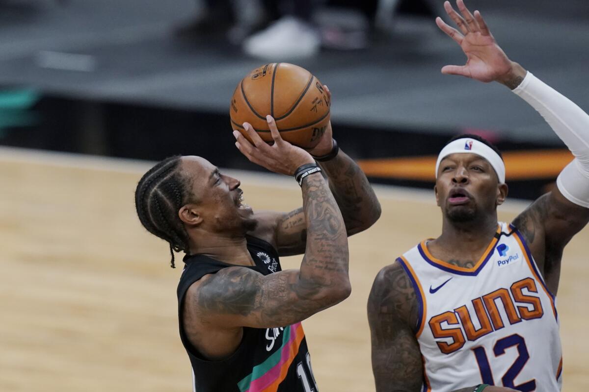 Spurs forward DeMar DeRozan attempts a shot over Suns forward Torrey Craig.