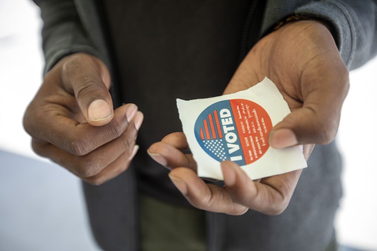 A man holds an "I voted" sticker at Crenshaw High on Tuesday.