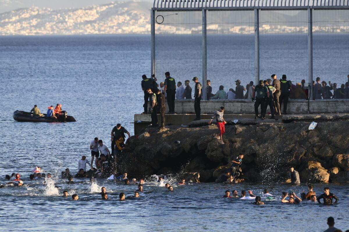 Spanish officers trying to stop swimming migrants