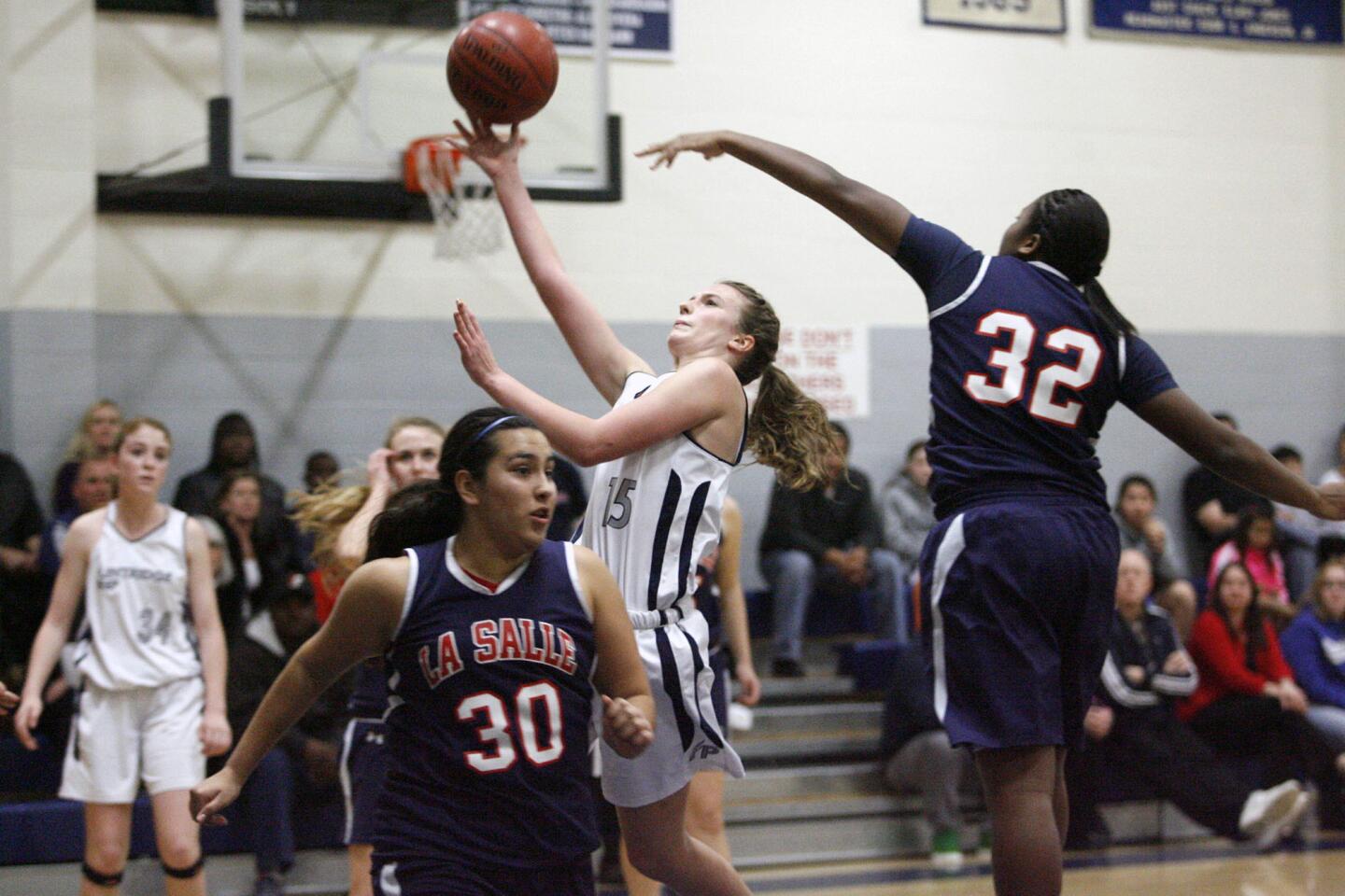 Flintridge Prep's Lacy Coan, center, shoots the ball and is blocked by La Salle's Kandyce Smith during a game at Flintridge Prep on Saturday, January 26, 2013.