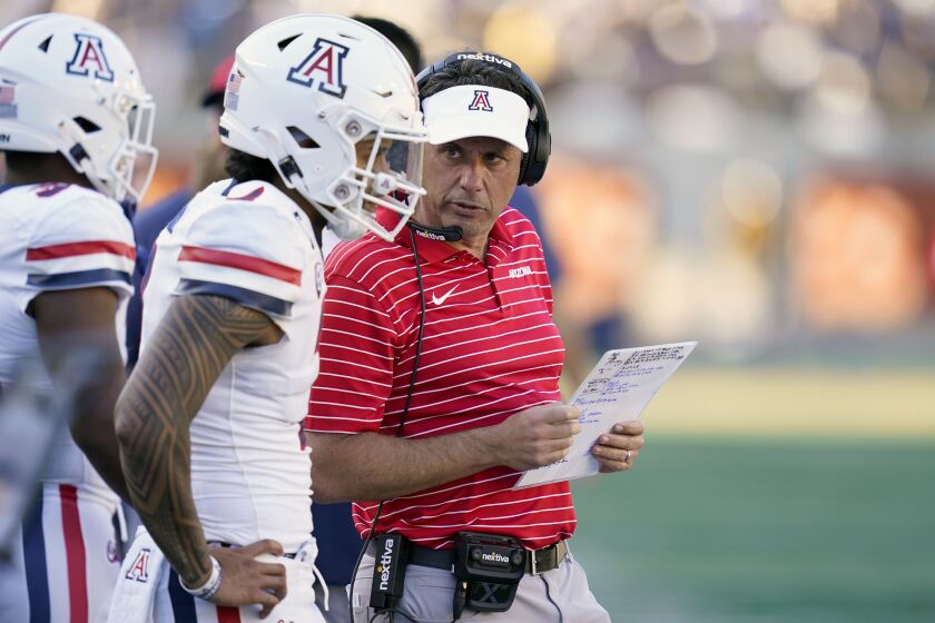 Arizona head coach Jedd Fisch, right, talks with quarterback Jayden de Laura, second from left, before the offense took the field against California during the second half of an NCAA college football game in Berkeley, Calif., Saturday, Sept. 24, 2022. (AP Photo/Godofredo A. Vásquez)
