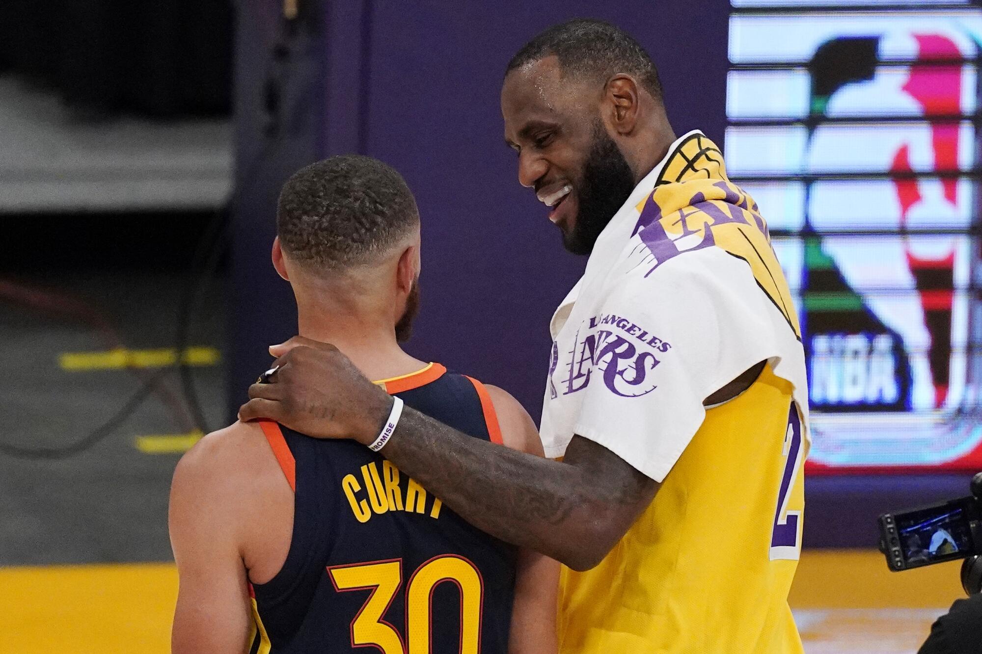 Los Angeles Lakers forward LeBron James, right, greets Golden State Warriors guard Stephen Curry.