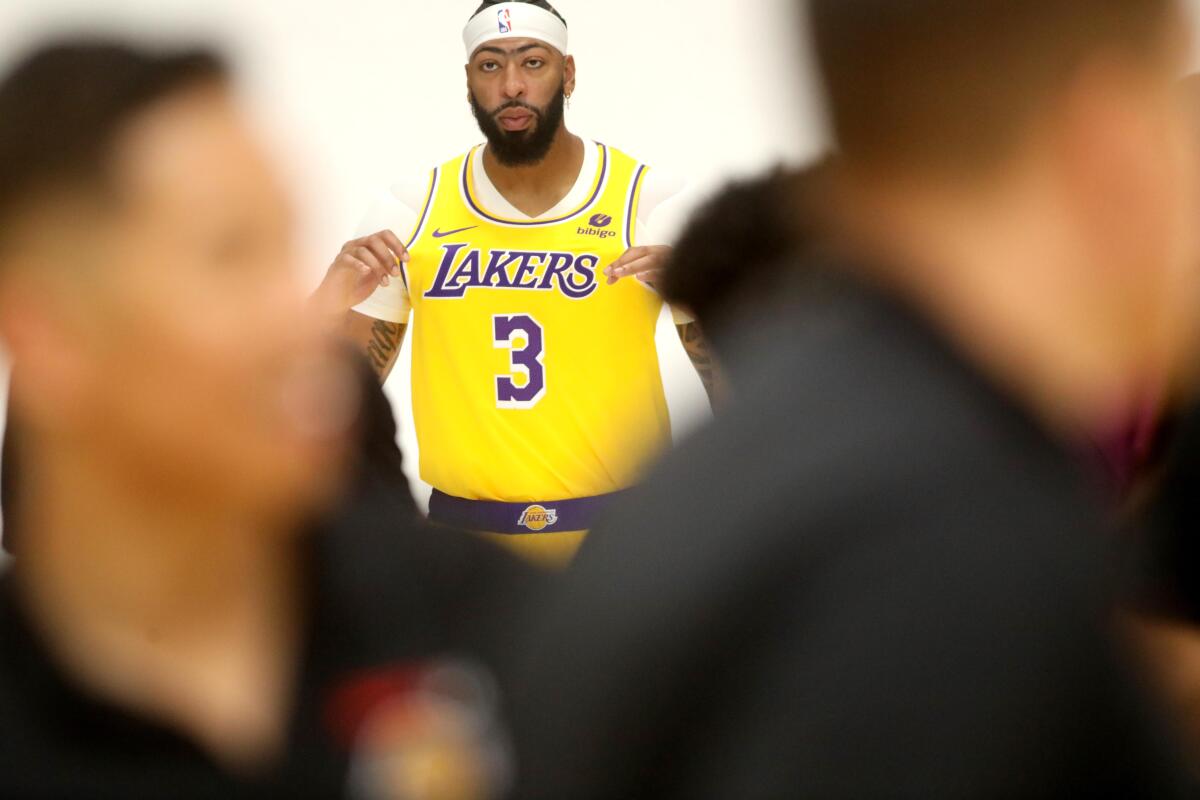 Lakers star Anthony Davis is watched by reporters as he has his photo taken during media day.