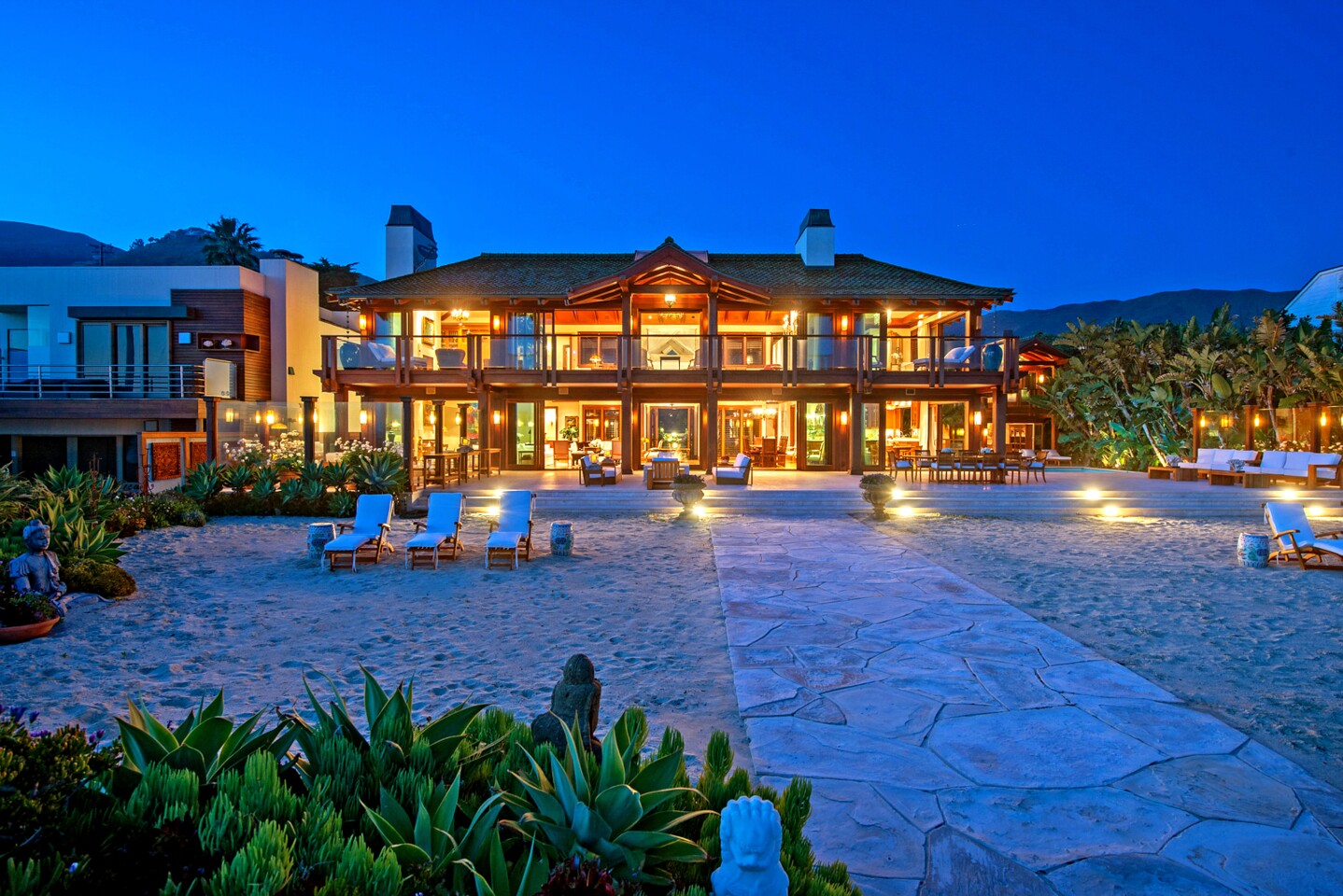 "James Bond" star Pierce Brosnan is shooting for nine figures in Malibu, where his Thai-inspired retreat on Broad Beach just hit the market for $100 million. The oceanfront retreat spans more than an acre with two homes that combine for five bedrooms and 14 bathrooms. Past a pair of carved teak gates, the verdant grounds are filled with palm trees, tropical flowers, travertine courtyards and wraparound lanais.