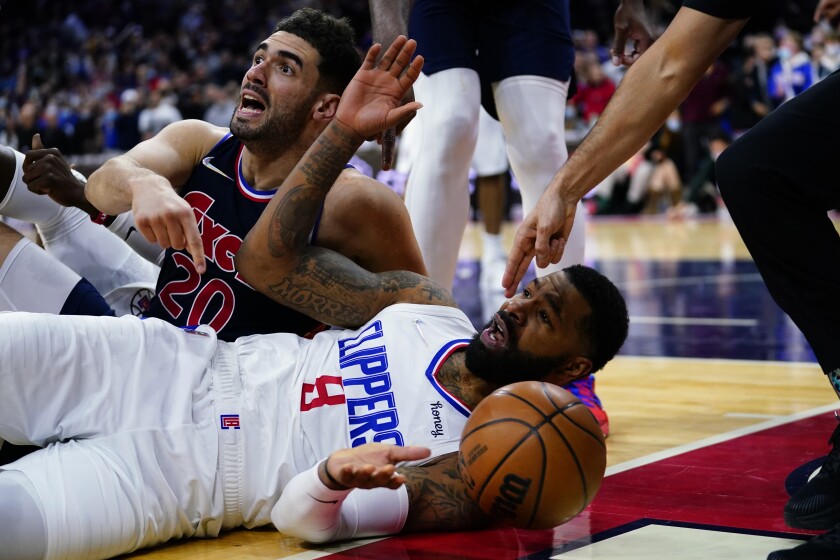 Clippers forward Marcus Morris Sr. and 76ers forward Georges Niang dive to the court for a loose ball.