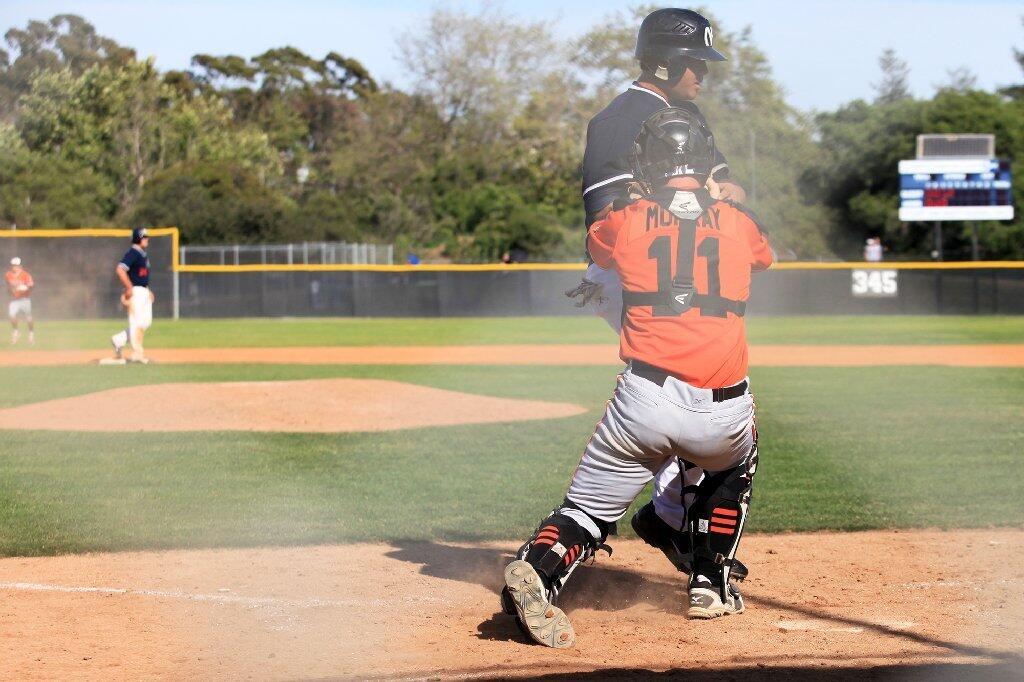 Huntington Beach High catcher Tyler Murray (11) tags out Newport Harbor's Keith Marshall completing a triple play to close out the fourth inning in a Sunset League game on Tuesday.