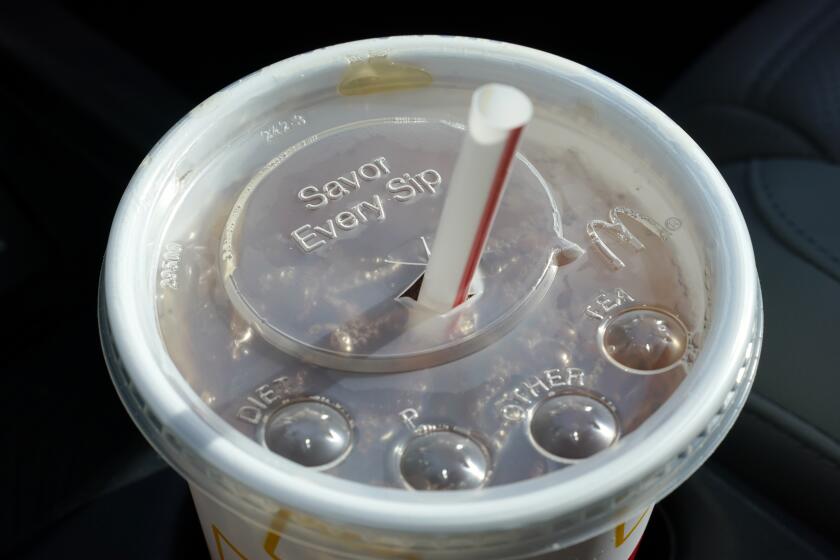 FILE - A McDonald's beverage sits in a cup holder, April 27, 2021, in Des Moines, Iowa. McDonald's plans to eliminate self-service soda machines at all of its U.S. restaurants by 2032, the Chicago-based fast food chain has confirmed. In an email to The Associated Press on Tuesday, Sept. 12, 2023, McDonald's USA said the goal of the change is to create consistency for customers and crew members across the chain's offerings — from in-person dining to online delivery and drive-thru options. (AP Photo/Charlie Neibergall, File)