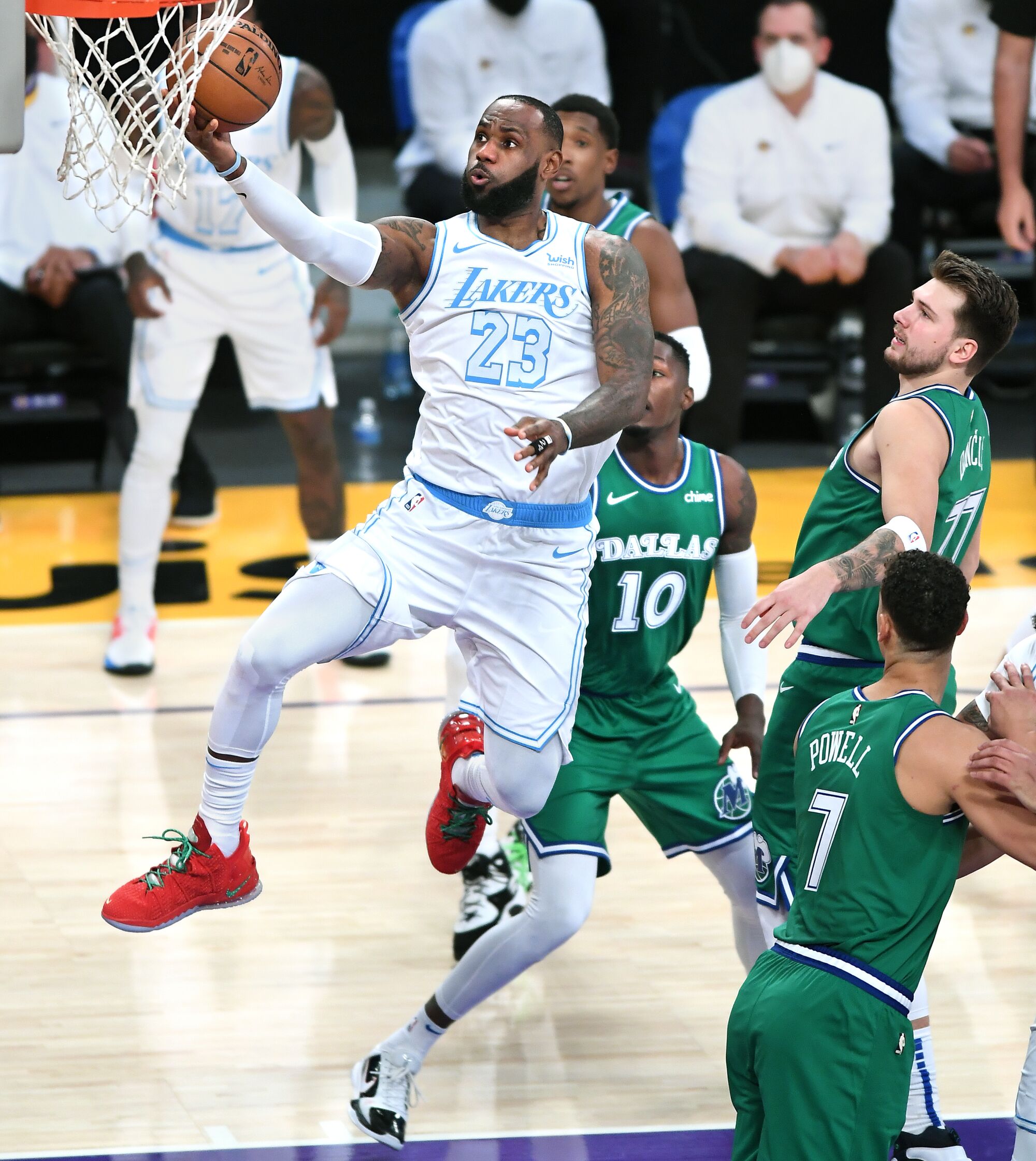Lakers star LeBron James drives through the Mavericks defense to score during the first quarter.