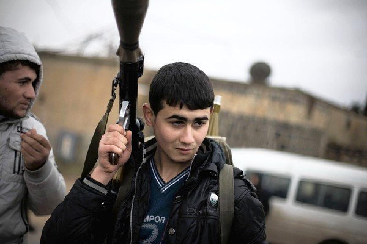 A Syrian rebel prepares to advance against government troops in Azaz.