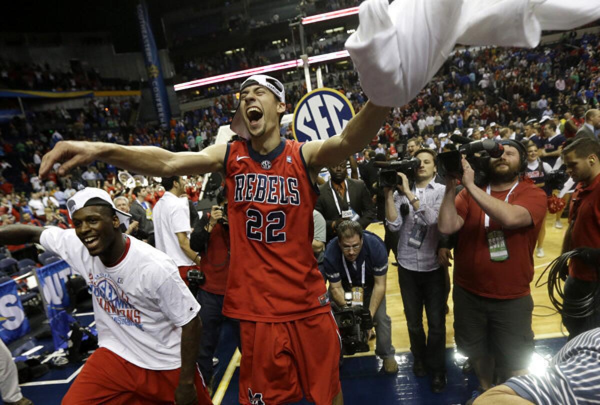 Mississippi guard Marshall Henderson (22) and a teammate celebrate after the Rebels earned an automatic bid to the NCAA tournament with a victory over Florida in the SEC tournament title game Sunday.