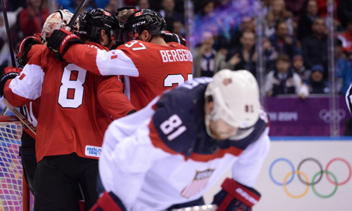 Team USA forward Phil Kessel, right, skates off the ice as Team Canada celebrates its 1-0 in the semifinals of the Sochi Winter Olympics on Friday. The U.S. will play Finland in the bronze-medal game.