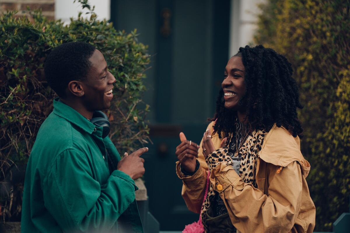 A man and a woman face each other, smiling