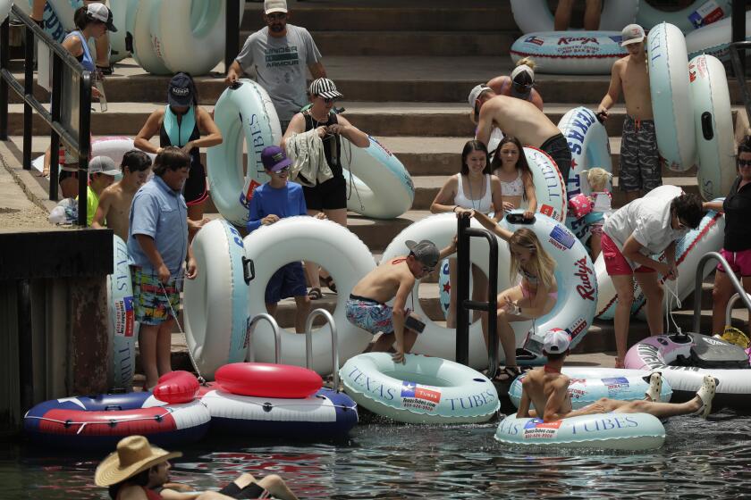 Tubers prepare to float the Comal River despite the recent spike in COVID-19 cases, Thursday, June 25, 2020, in New Braunfels, Texas. Texas Gov. Greg Abbott said Wednesday that the state is facing a "massive outbreak" in the coronavirus pandemic and that some new local restrictions may be needed to protect hospital space for new patients. (AP Photo/Eric Gay)