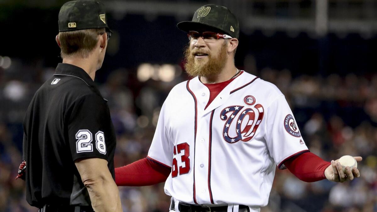 Nationals relief pitcher Sean Doolittle speaks with umpire Jim Wolf after Cubs manager Joe Maddon (not pictured) complained about his pitching mechanics during the ninth inning Saturday night.