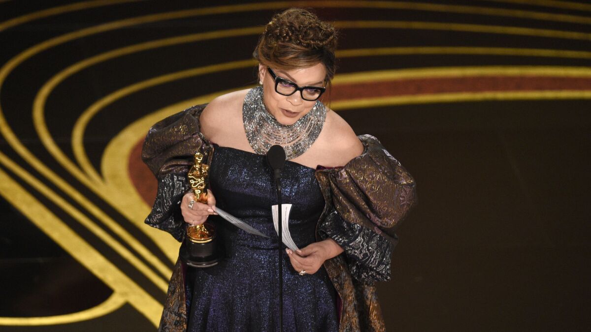 Ruth E. Carter accepts the Oscar for costume design on Sunday.