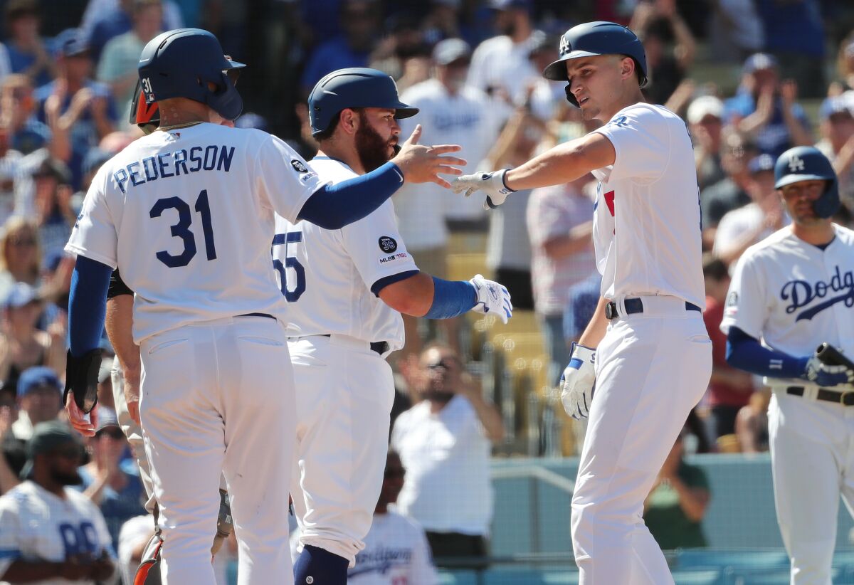 Dodgers shortstop Corey Seager gets high-fives from teammates Joc Pederson (31) and Russell Martin (55)after hitting a three-run home run against the San Francisco Giants on Sunday.