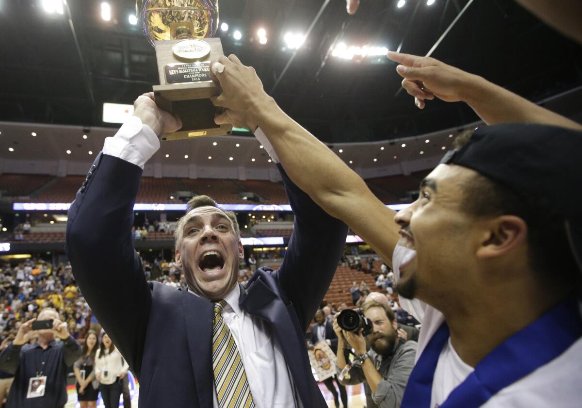 UC Irvine Coach Russell Turner holds up the Big West Conference tournament championship as he and his players celebrate the title and automatic NCAA tournament berth.