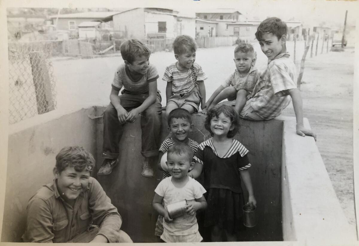 Niños juegan en un tanque de agua vacío en una foto familiar de alrededor de 1960