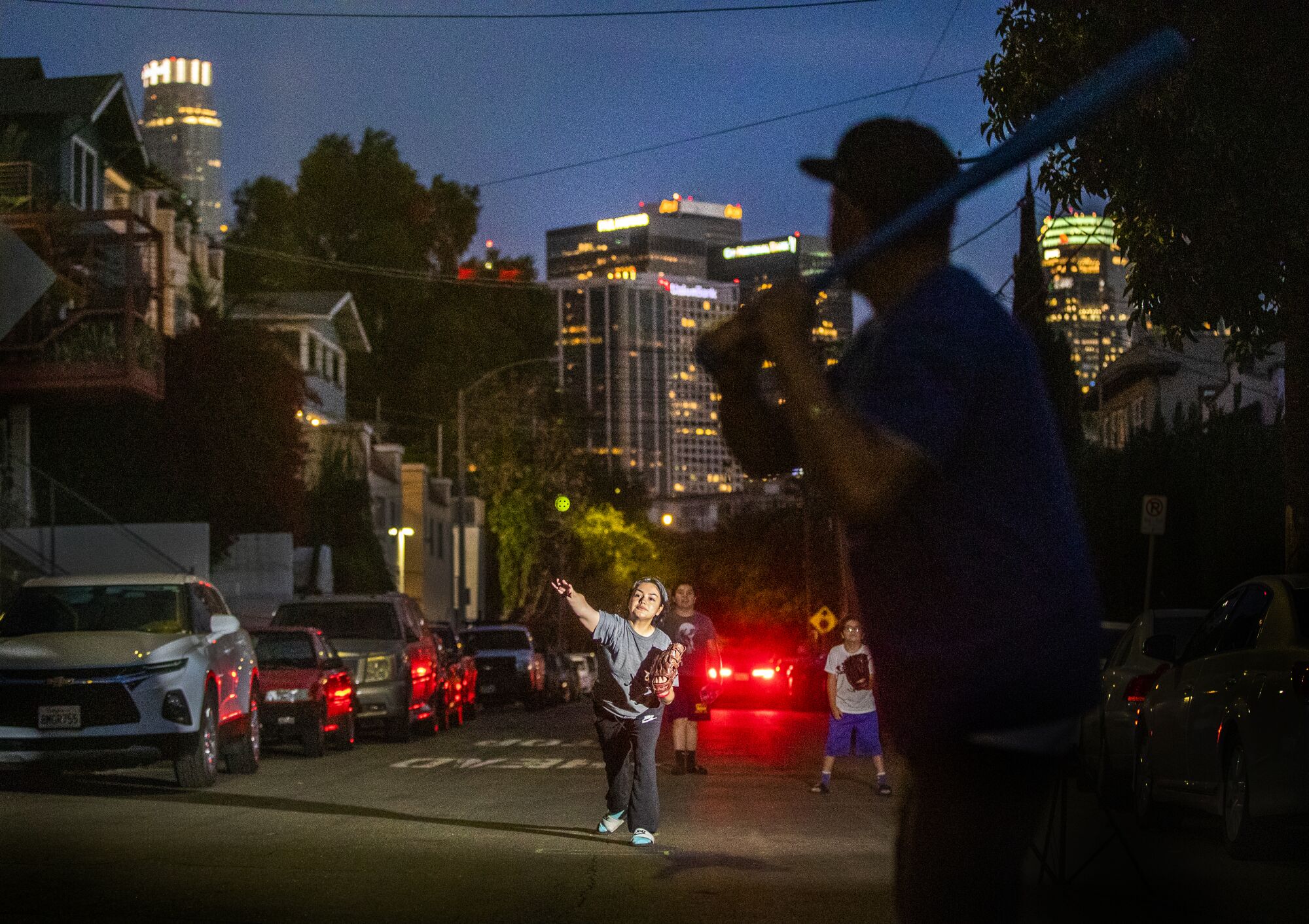 April 6: Amid pleasant weather at dusk, a family plays baseball along Douglas Street with a view of downtown Los Angeles.