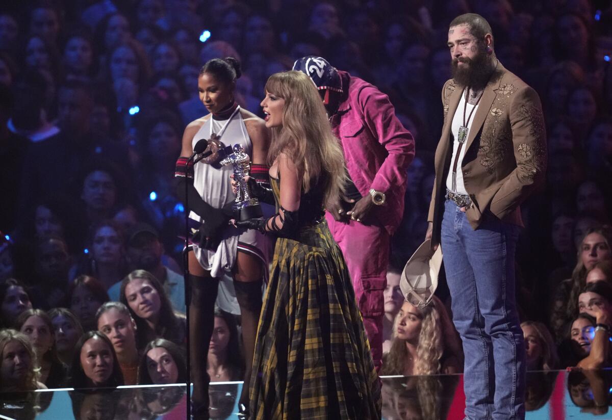 Taylor Swift, center, and Post Malone, far right, accept the award for best collaboration 